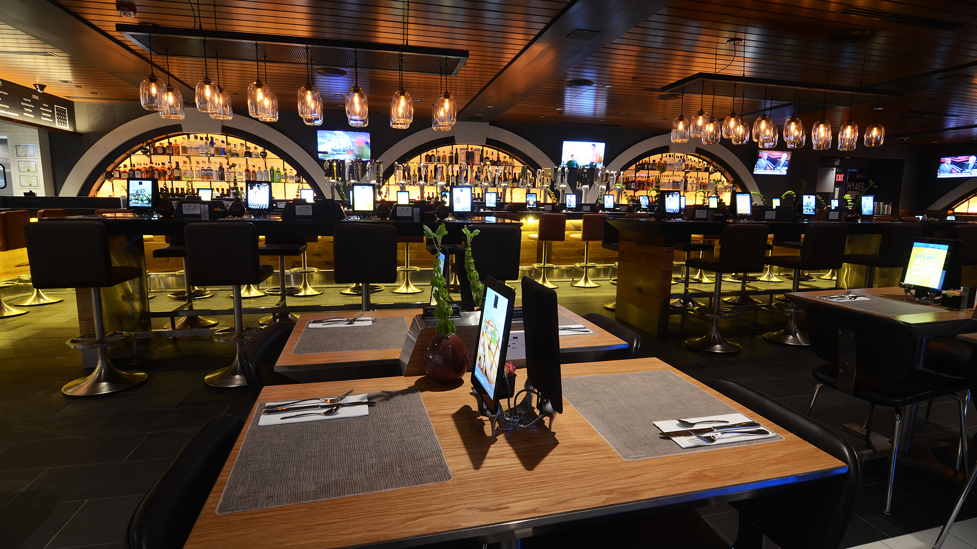 Tavern image showing arched liquor displays behind the bar, tables in foreground